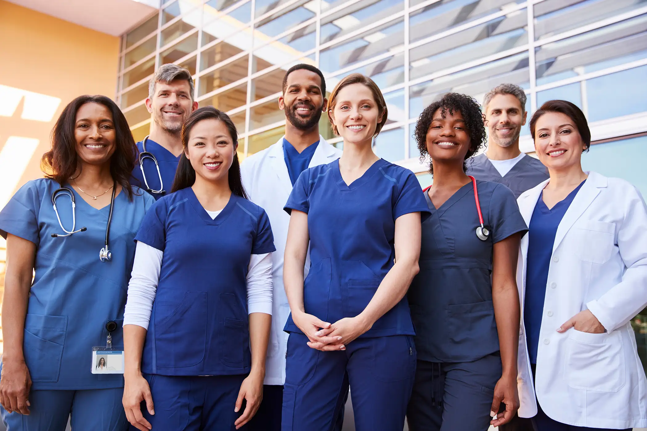 AdobeStock_213032344 (1) copy Smiling medical team standing together outside a hospital