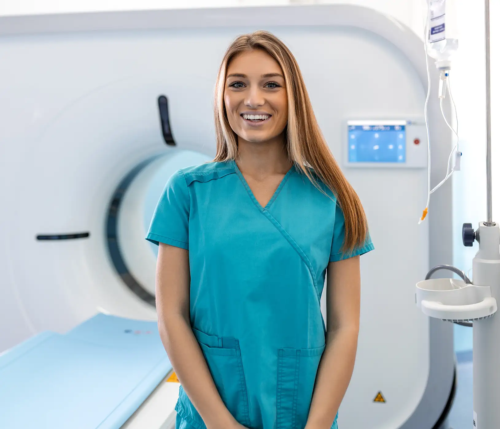 AdobeStock_594166041 copy Beautiful happy female doctor physician radiologist standing in CT CAT Scan room at hospital.